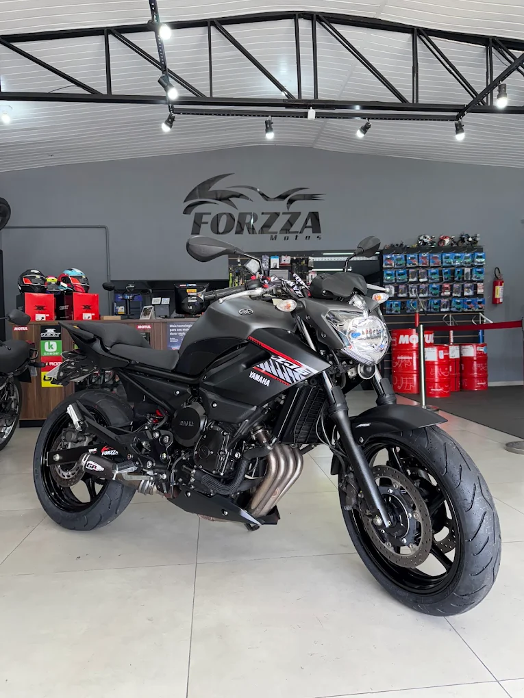 Motocicleta exposta na área de motos da Forzza, com a marca da oficina ao fundo